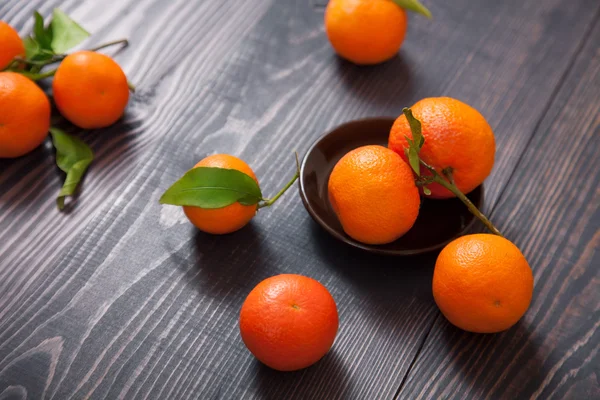 Várias tangerinas maduras em uma mesa de madeira — Fotografia de Stock