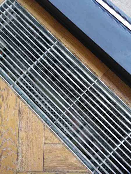 Yerdeki ahşap zeminde havalandırmalı ısıtma ızgarası..