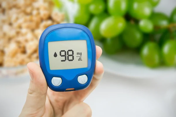 Diabetes a fazer teste de glicemia. Frutas no fundo — Fotografia de Stock