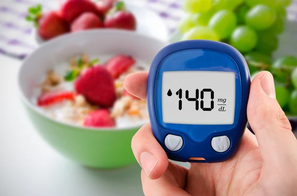 Diabetes haciendo pruebas de nivel de glucosa. Frutas en segundo plano — Foto de Stock