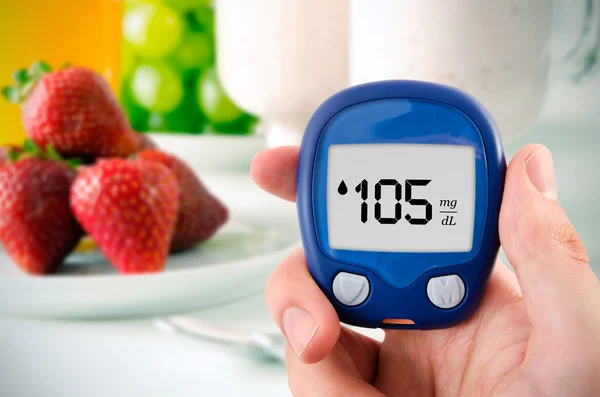 Diabetes doing glucose level test. Fruits in background — Stock Photo, Image