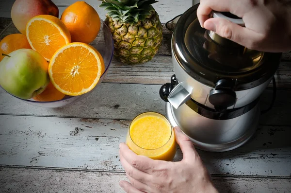 Hombre preparando jugo de naranja fresco. Frutas en segundo plano —  Fotos de Stock