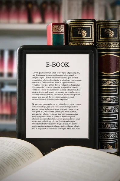 Lector de libros electrónicos en el escritorio en la biblioteca — Foto de Stock