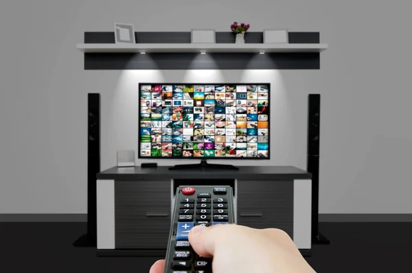 Tévénézés modern Tv-szobában. Kezében a távoli — Stock Fotó