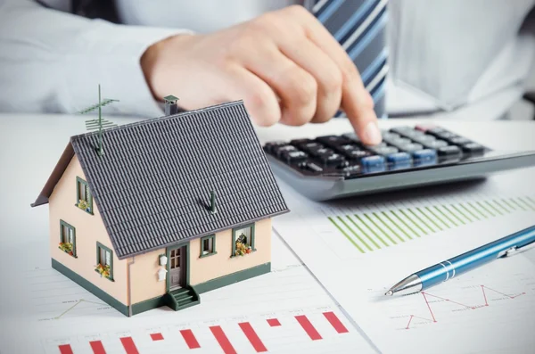 Empresário calcular o custo de construção e manutenção de casa — Fotografia de Stock