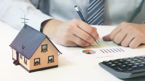 Biznesmen obliczyć koszty budowy domu — Wideo stockowe
