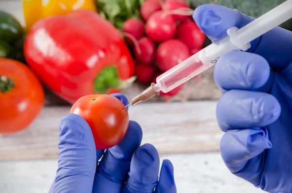 Analyst injects liquid into apple. Genetically modified food concept — Stock Photo, Image