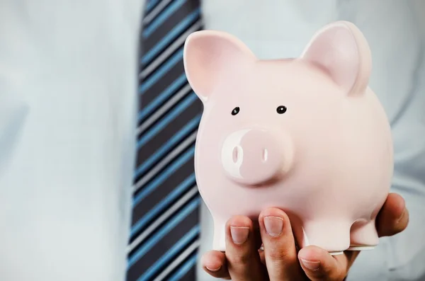 Zakenman piggy bank in de hand houden — Stockfoto