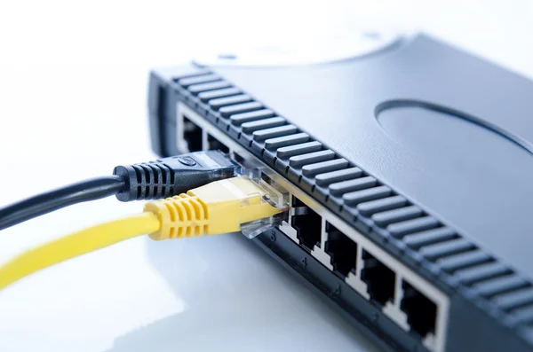 Network switch device and ethernet cables on white — Stock Photo, Image
