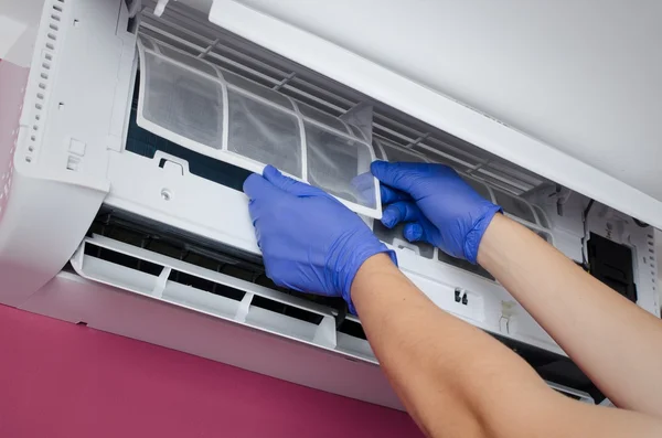 Air conditioner schoonmaken. Man controleert het filter. — Stockfoto