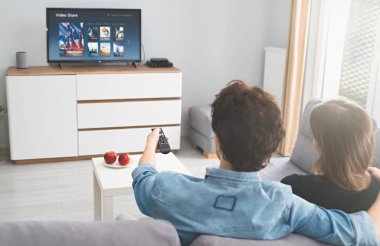 Kanepede televizyon izleyen bir çift. Televizyon, multimedya, talep üzerine video