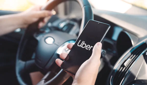 Wroclaw ポーランド 2020年8月25日 車の中でスマートフォンを保持するUberドライバー Uberは Ubran輸送のシェアリングエコノミーサービスです — ストック写真