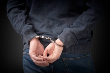 Suçlu kelepçeli, arka görüş. Suçlu tutuklandı, güvenlik kavramı