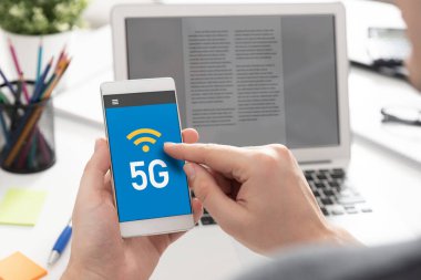 5G teknolojisi, yüksek hızlı iletişim, veri iletimi. El ele tutuşan akıllı telefon.