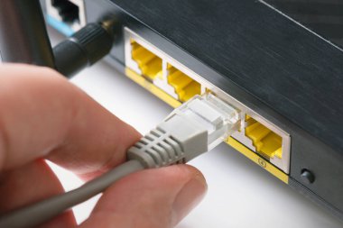 Router Wi-Fi 'ı kapatın. Hızlı internet modem cihazı. Adam ethernet kablosunu prize takıyor