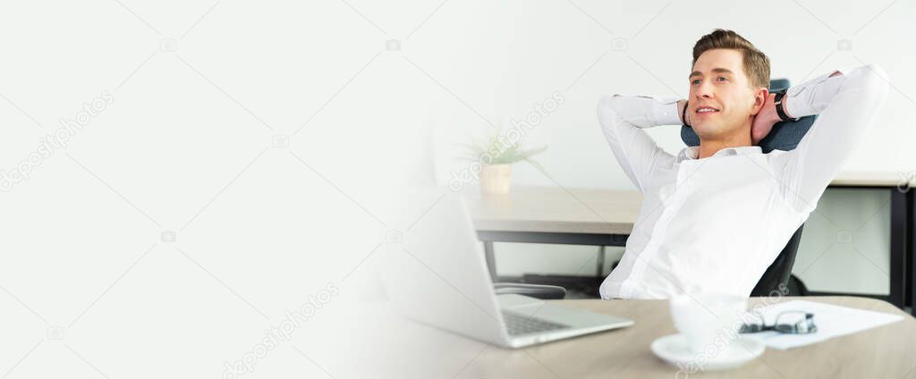 Businessman relaxing in office after hard working day. Happy employee sitting on a chair in the office