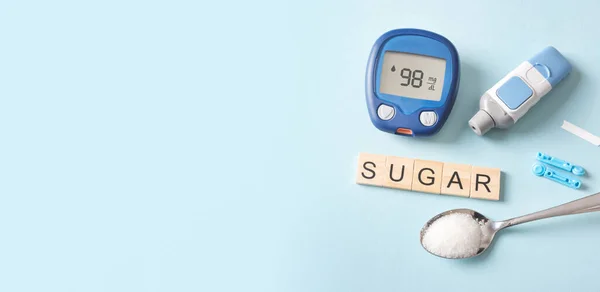 Treatment and controlling diabetes concept. Glucometer, spoon with sugar.