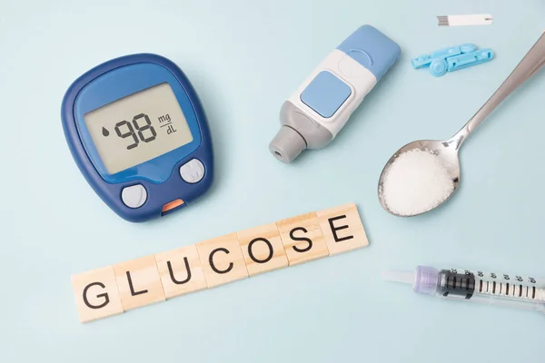 Treatment and controlling diabetes concept. Glucometer, spoon with sugar.