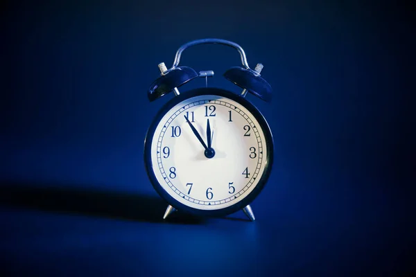 アナログ時計のフロントビュー ダークブルーの背景 — ストック写真