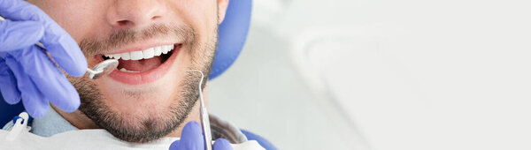 Young man at the dentist. Dental care, taking care of teeth. Picture with copy space for background.