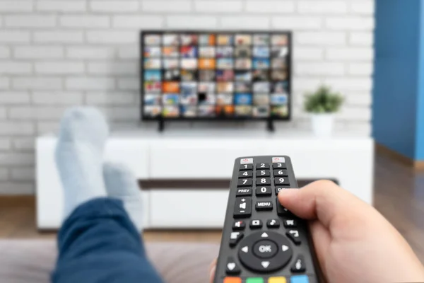 Man Watching Lying Sofa Legs Table Person Holding Remote Control — Stock Photo, Image