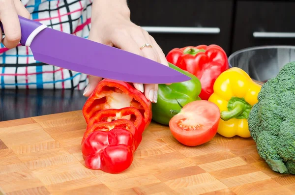Kocken förbereder mat, skär paprikan i skivor — Stockfoto