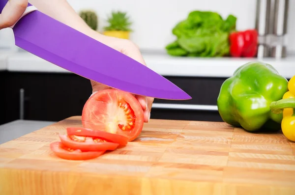 Kocken förbereder mat, skär tomater i skivor — Stockfoto