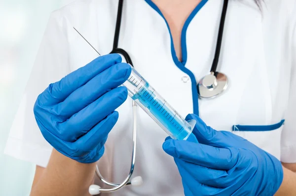 Mujer médico con guantes que sostiene la jeringa de inyección médica y s — Foto de Stock