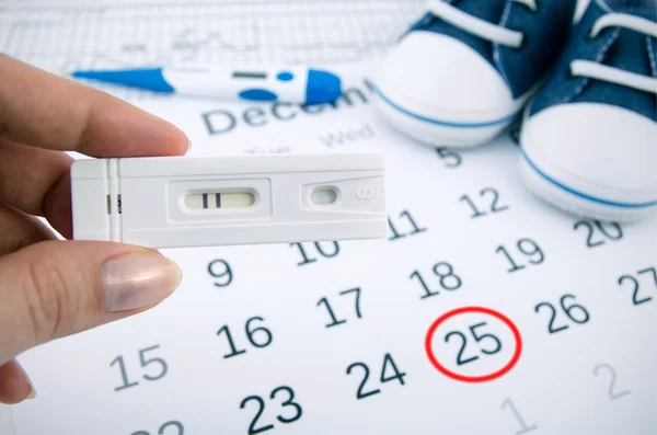 Positieve zwangerschapstest op kalender met datum van geboorte — Stockfoto