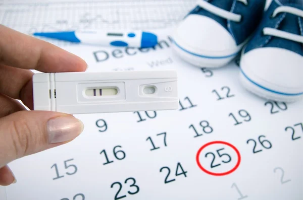 Prueba de embarazo positiva en el calendario con fecha de nacimiento — Foto de Stock