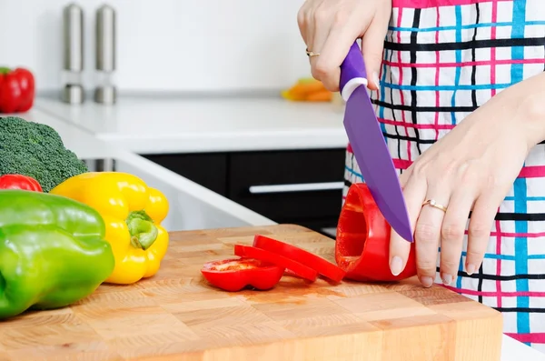 Vrouw chef-kok snijden paprika's. voedselbereiding in moderne keuken — Stockfoto