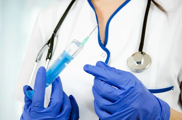 Mujer médico con guantes que sostiene la jeringa de inyección médica y s — Foto de Stock