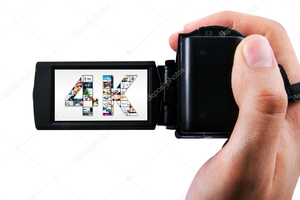 Hand holding Ultra High Definition camcorder isolated on white