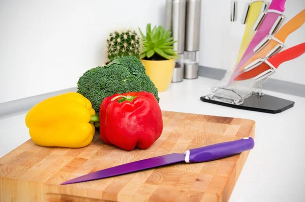 Légumes frais sur une planche à découper dans la cuisine — Photo