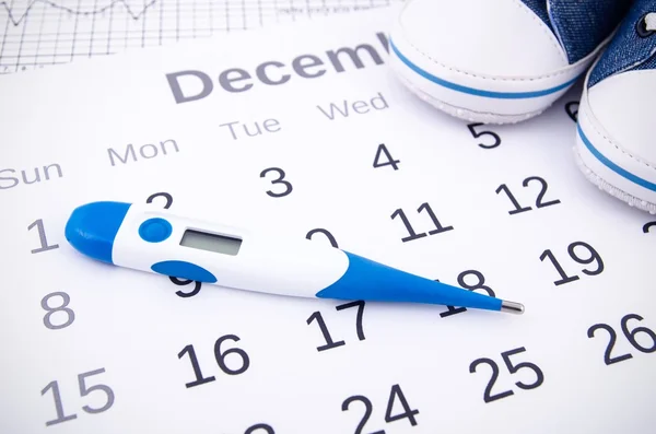 Termômetro eletrônico no conceito de fertilidade no calendário — Fotografia de Stock