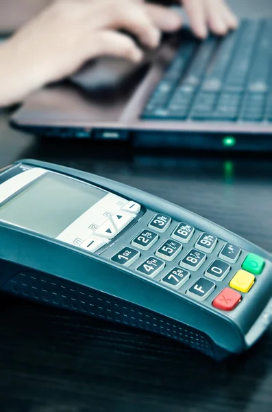 Payment terminal in the office. Man working with laptop in the b — Stock Photo, Image