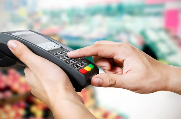 सुपरमामध्ये विक्रीसाठी टर्मिनलद्वारे क्रेडिट कार्ड हाताने स्विप करा — स्टॉक फोटो, इमेज
