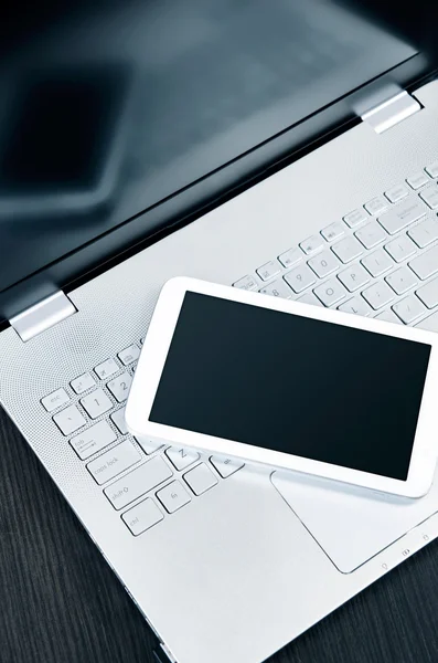 Laptop com tablet digital branco na mesa — Fotografia de Stock