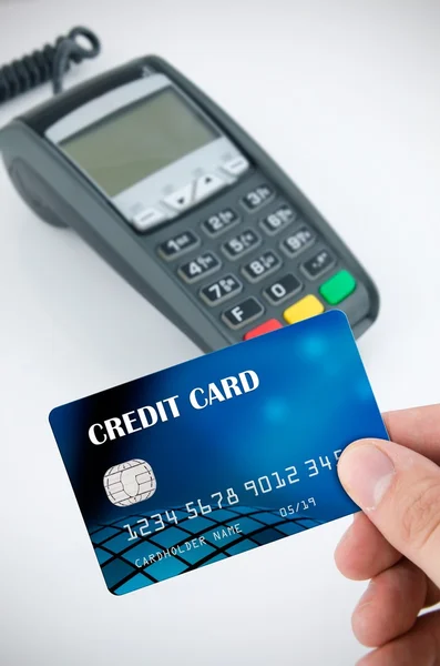 Hand holding credit card. Payment terminal in background — Stock Photo, Image