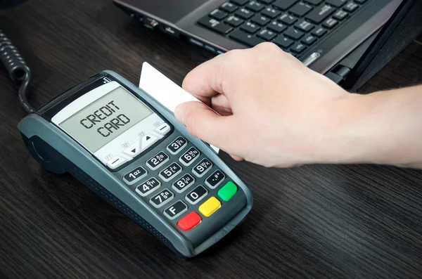 Man pays with credit card. Swiping plastic card through terminal — Stock Photo, Image