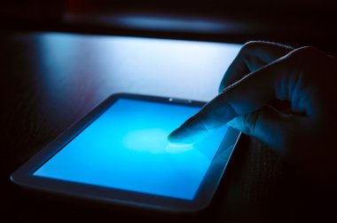 Tablet ekranda dokunmadan parmak. Geceleri aygıt kullanma