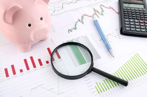 Magnifier and piggybank od desk. Saving money business concept — Stock Photo, Image