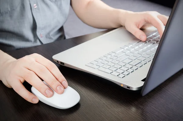 Man aan het werk in office. Laptop met witte toetsenbord en witte mous — Stockfoto