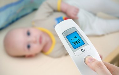 Measuring temperature to a baby with digital thermometer clipart