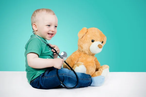 Kind ist Arzt. Spielen mit Teddybär — Stockfoto