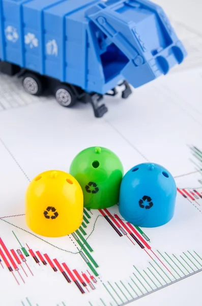 Colored trash bins and garbage truck toys on business background — Stock Photo, Image