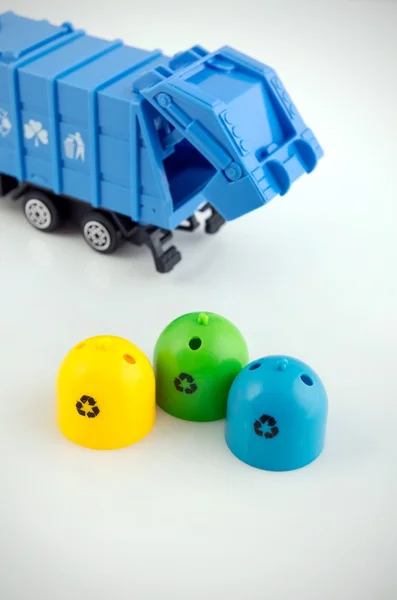 Farbige Mülltonnen und Müllwagen-Spielzeug auf weißem Hintergrund — Stockfoto