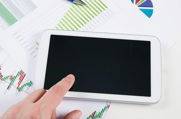 Businessman working with digital tablet. Report charts on desk