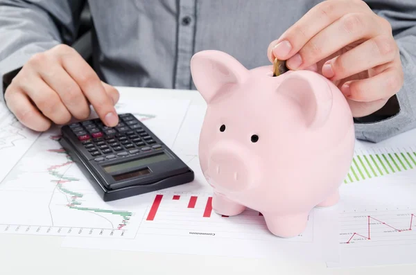 Man putting coin in piggy bank. Saving money concept — Stock Photo, Image