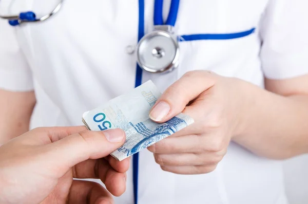Patient bribing doctor, giving money to the hand — Stock Photo, Image